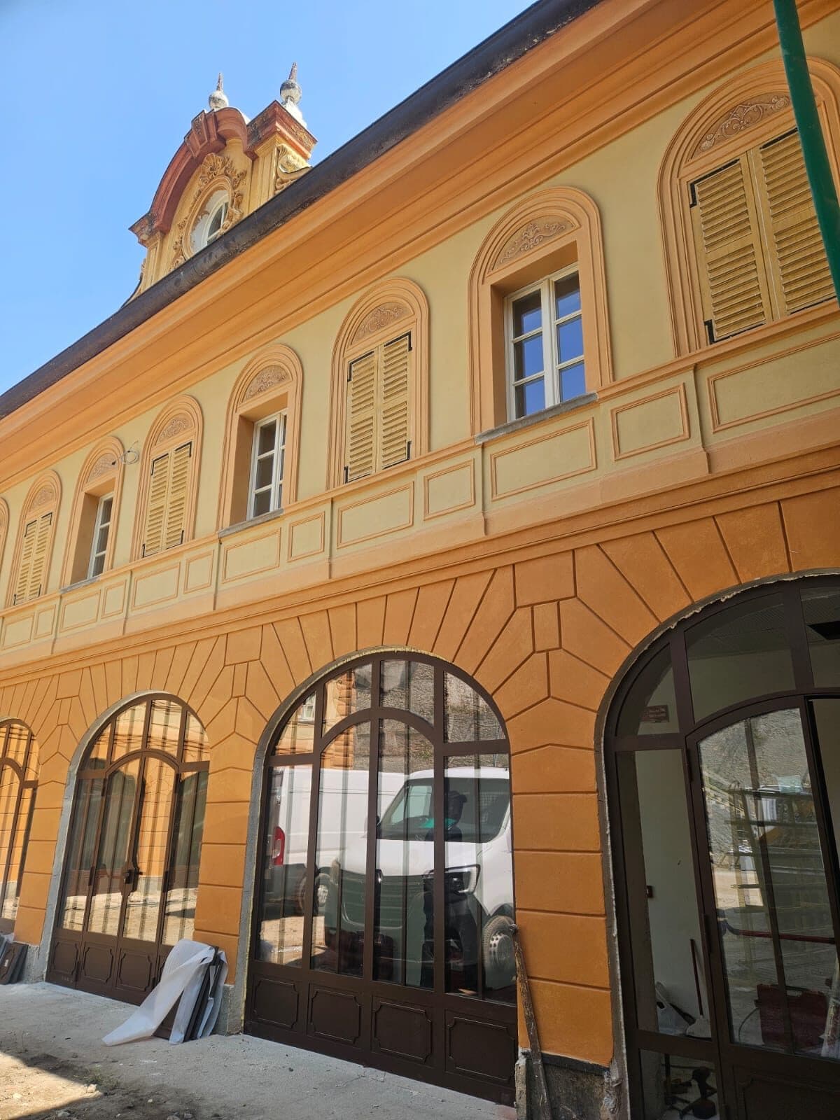 Facciata di un palazzo storico restaurato: portali ad arco in alluminio color bronzo