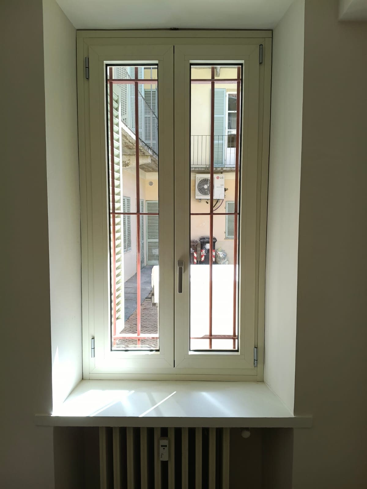 Sul retro, la finestra a due ante color avorio vista dall'interno