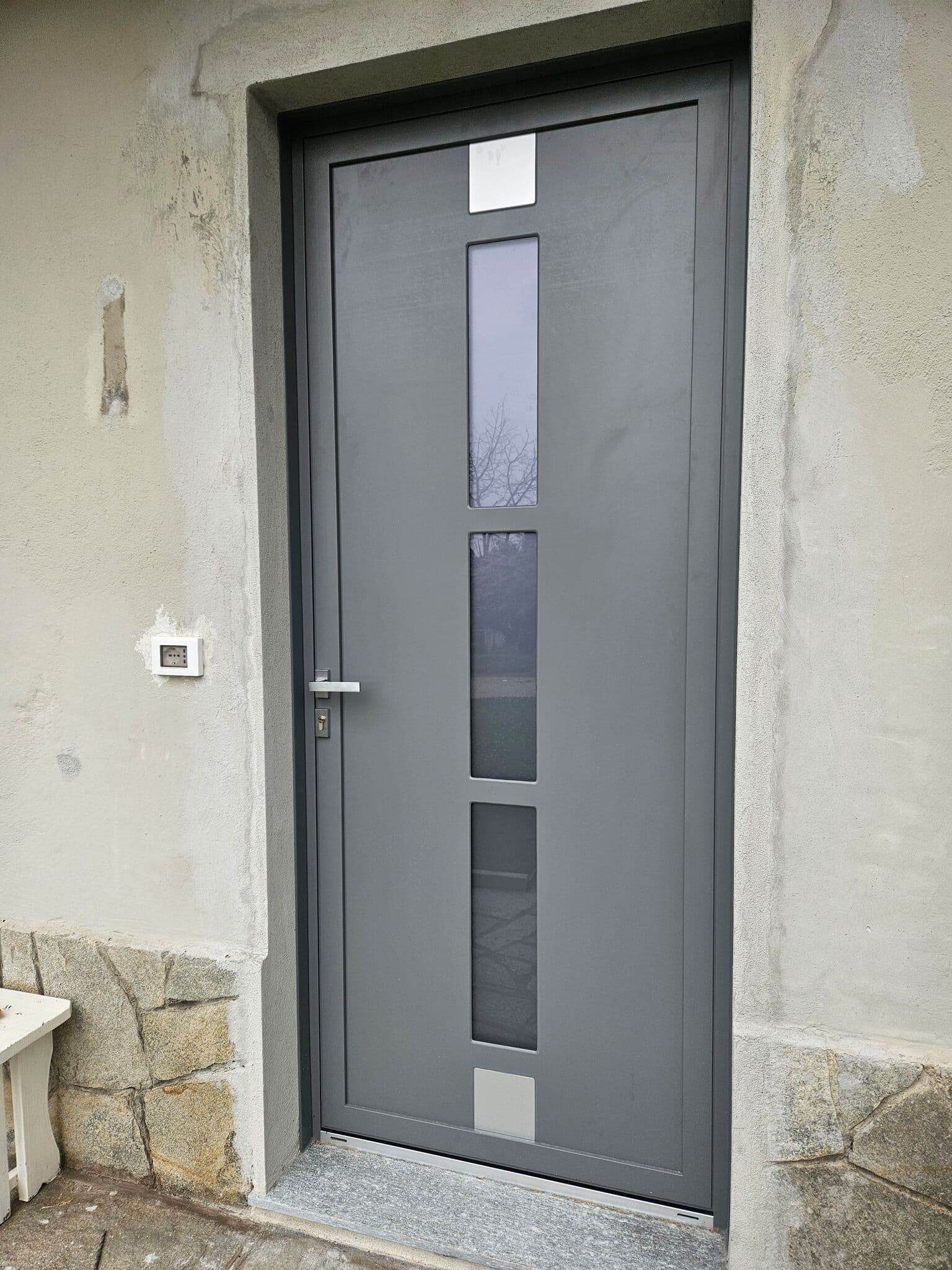 Portoncino d'ingresso grigio con tre inserti vetrati