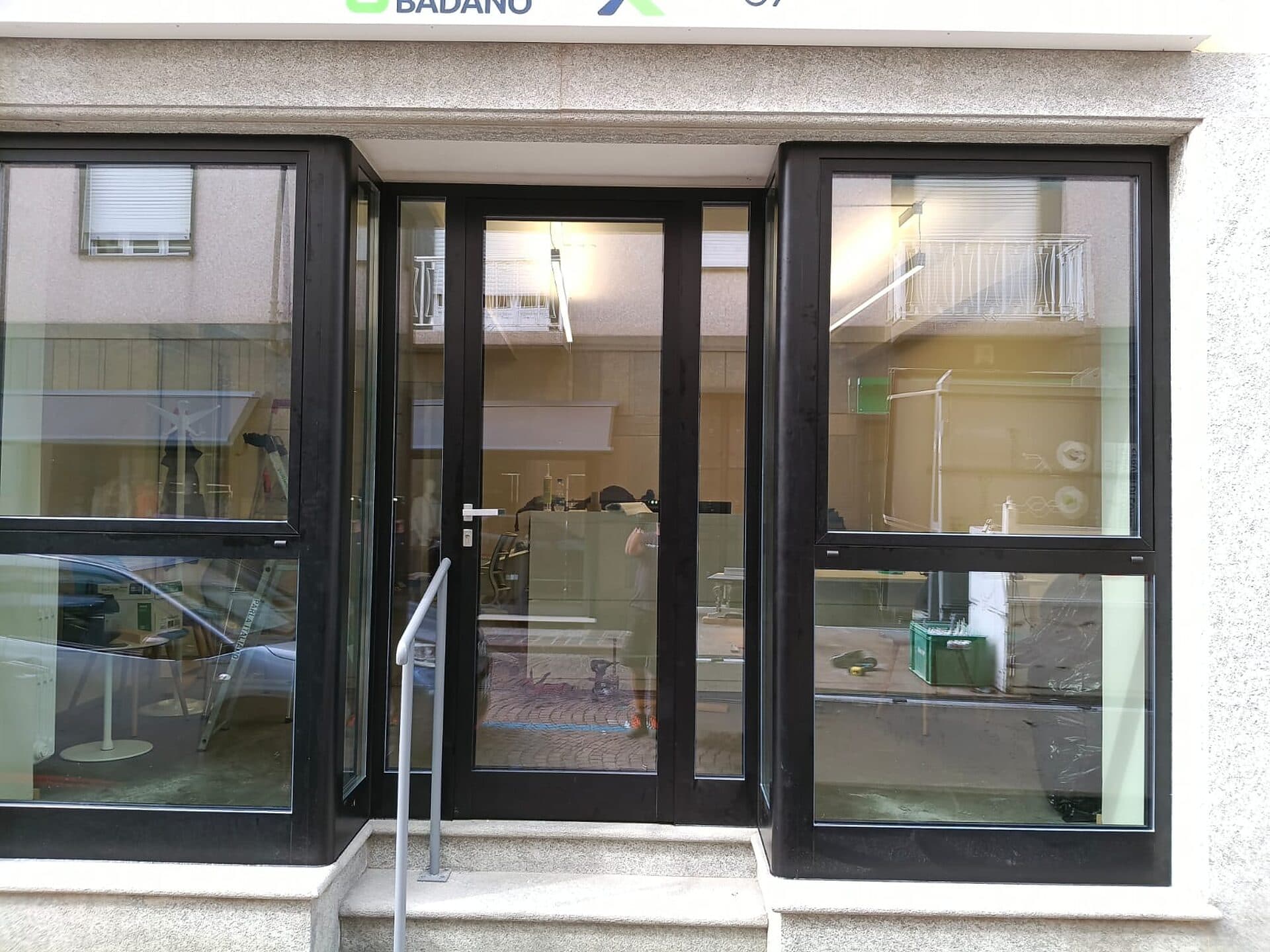 Il negozio dalla strada: porta d'ingresso vetrata al centro, fra due vetrine con telaio scuro e traverso